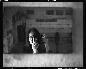 Monochrome photo of a woman in a mirror taking a photo of herself